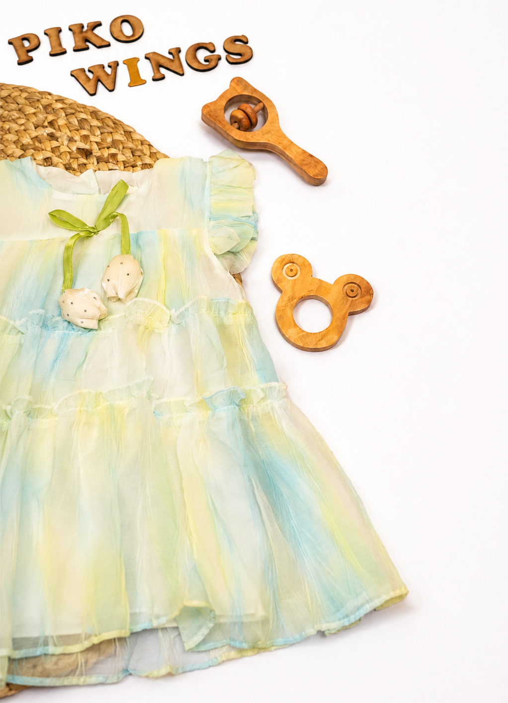 A pastel tiered dress with a green bow and coconut embellishment,