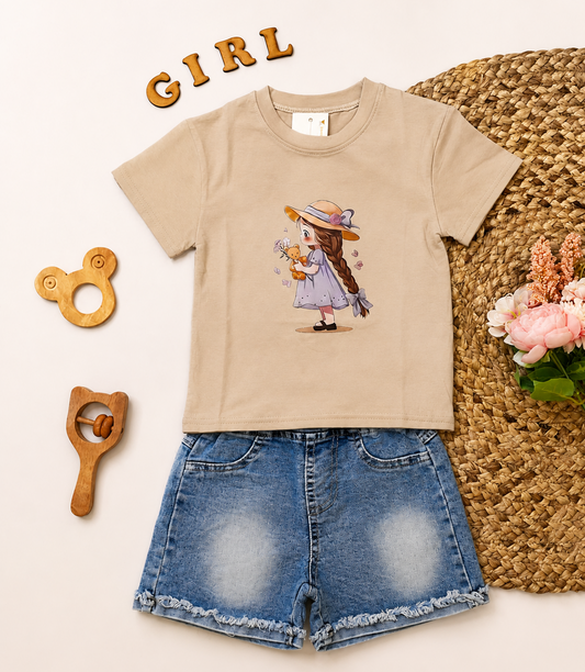 A children's outfit set featuring a beige short-sleeve t-shirt with a cartoon girl graphic, paired with blue denim shorts