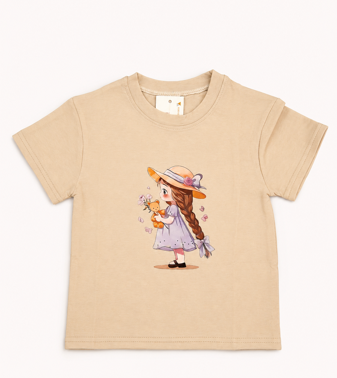 A beige short-sleeve kids' t-shirt featuring a central graphic print of a cute cartoon girl with long brown hair, wearing a lavender dress and straw hat while holding a small orange animal, displayed on a clean white background.